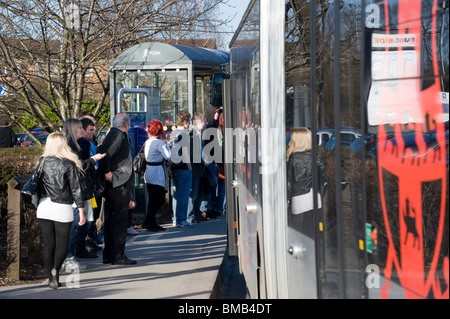 I passeggeri di salire a bordo di un autobus alla fermata in Inghilterra Foto Stock