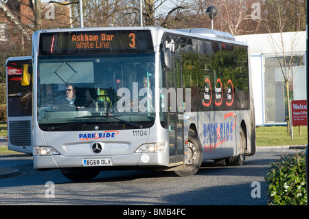 Parco e autobus lasciando un parcheggio in centro città in Inghilterra. Foto Stock