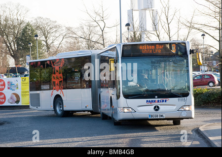 Il park and ride bendy bus lasciando un parcheggio in centro città in Inghilterra. Foto Stock