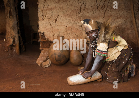 Donna Kikuyu macinazione di mais, Nyeri, Highlands Centrali, Kenya Foto Stock