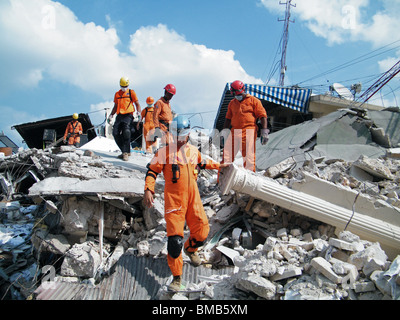 Il domenicano Defensa civile ricerche del team per i superstiti in macerie nel centro di Port au Prince dopo il terremoto di Haiti Foto Stock