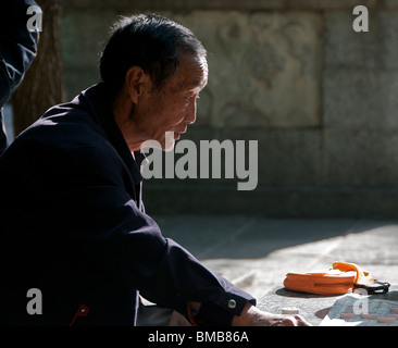 Il vecchio uomo di concentrare sul cinese gioco di scacchi Dali Cina Yunnan Foto Stock