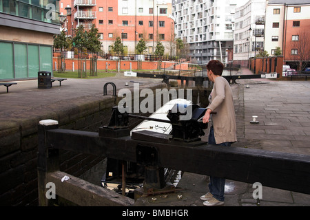 Donna che utilizza un blocco del canale, Barge, passando attraverso la serratura 89, Rochdale Canal, Manchester, Regno Unito Foto Stock