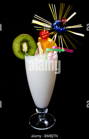 La Pina Colada su sfondo nero, guarnite con fette di kiwi e arancione. Foto Stock