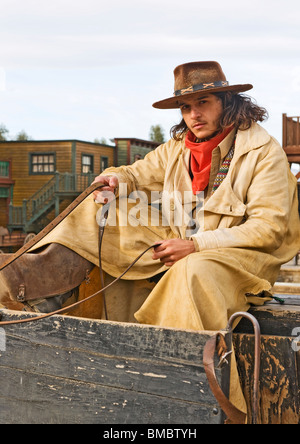 Cowboy seduto sul suo carro nel vecchio west set cinematografico Foto Stock