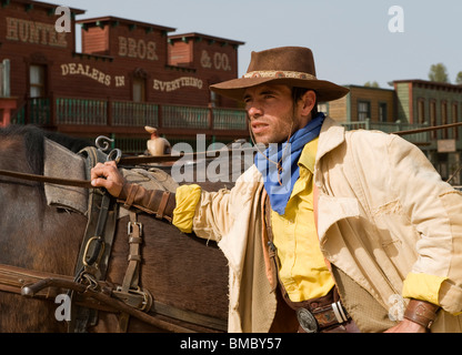 Primo piano di un cowboy in piedi accanto al suo cavallo nel vecchio west Foto Stock