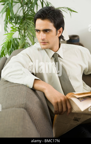 Imprenditore seduto su un divano e di pensiero Foto Stock