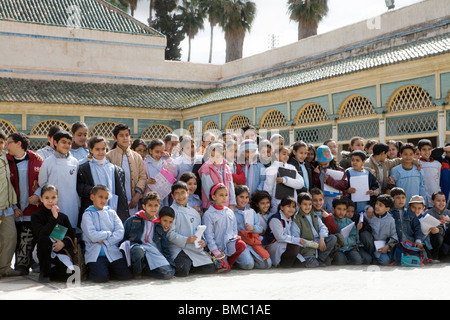 La scuola dei bambini in gita scolastica in posa nel cortile di El Palazzo Bahia , Marrakech , Marocco , il Nord Africa Foto Stock