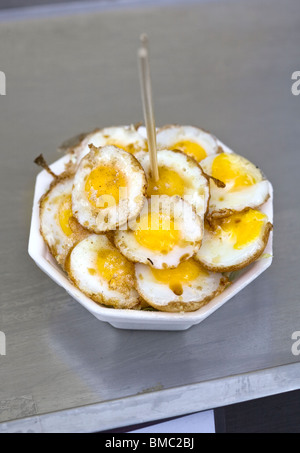 Frittura di uova di quaglia in vendita al mercato di Chatuchak Bangkok Foto Stock