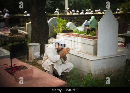 Uomo che prega in una tomba in un cimitero, Vecchia Delhi, India Foto Stock