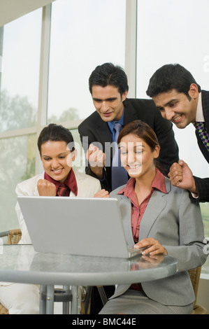 I dirigenti aziendali a celebrare il successo di fronte a un computer portatile Foto Stock