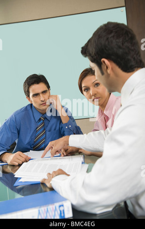 I dirigenti aziendali di discutere in una sala consiglio Foto Stock