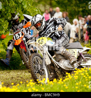 Classic demo di motocross presso la Baronia College open day due moto racing attraverso il campo della molla renoncules vicino a Dumfries Regno Unito Foto Stock