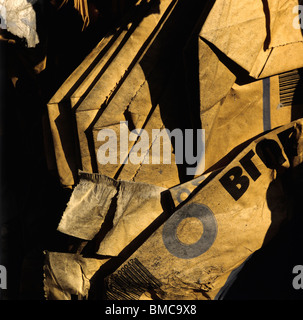 Sacchetti di carta marrone scartati impilati in un'area poco illuminata che rivela texture e ombre uniche Foto Stock