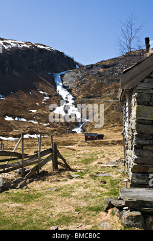 Cabine di vacanza in remoto la holo Valley che scorre veloce con cascata a cascata verso il basso Hillside Sogn Norvegia Foto Stock