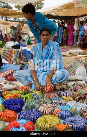 Etnici vendita donna bracciali vestito in colorate saree in occupato villaggio rurale del mercato India Kanha Foto Stock