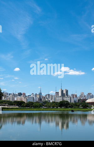 Alberi e Sao Paulo dello skyline della citta', che si riflette sul lago, visto dal Parque (parco) Ibirapuera, un grande parco urbano in Sao Paulo, Brasile Foto Stock