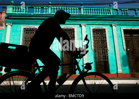 Un uomo che cavalca una bicicletta passato un edificio coloniale di Trinidad, Cuba Mercoledì 2 Luglio 2, 2008. Foto Stock
