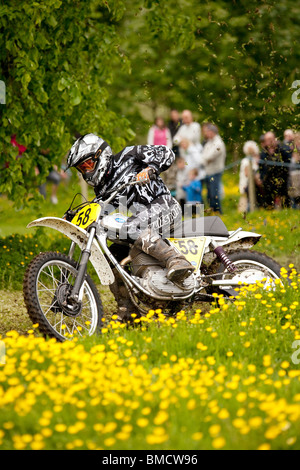 Classic demo di motocross presso la Baronia College open day moto racing attraverso il campo della molla renoncules vicino a Dumfries Foto Stock