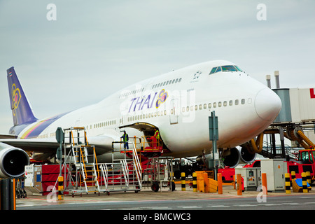 Un Thai Airways Boeing 747-400 in fase di caricamento si erge in un gate all'Aeroporto di heathrow Londra Inghilterra Foto Stock