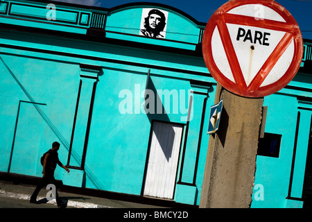 Un uomo cammina da un luminoso edificio blu adornata con un'immagine di Ernesto Che Guevara in Baracoa, Cuba il lunedì 14 luglio, 2008. Foto Stock