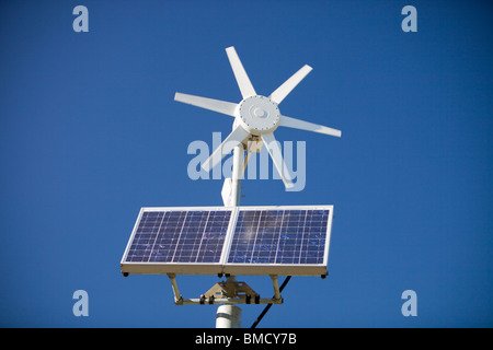 Un solare pannello elettrico e la turbina eolica essendo utilizzata per l'alimentazione di un neon di cartello stradale su Kirkstone Pass, Lake District, UK. Foto Stock