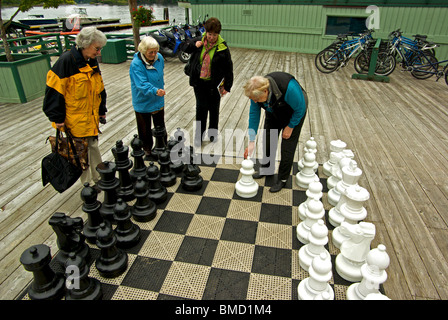 Le donne gli ospiti a giocare a scacchi sulla grande piattaforma in legno aprile Point Resort Spa Quadra Island BC Foto Stock