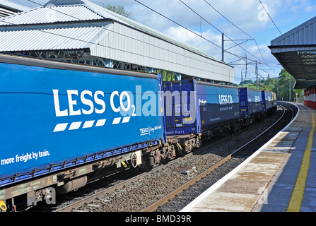 Tesco' meno CO2' contenitore treno merci. Linea principale costa occidentale. Stazione Oxenholme, Cumbria, England, Regno Unito Europa. Foto Stock