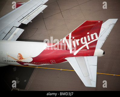 Pinna di coda e il logo aziendale di un Virgin Atlantic Airbus A340-300 sull'asfalto all'aeroporto di Londra Heathrow Foto Stock