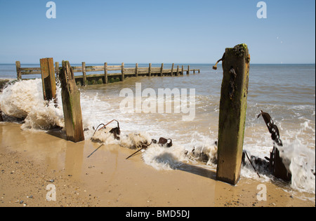 La rottura del mare su resti di mare difese a Happisburgh. Foto Stock