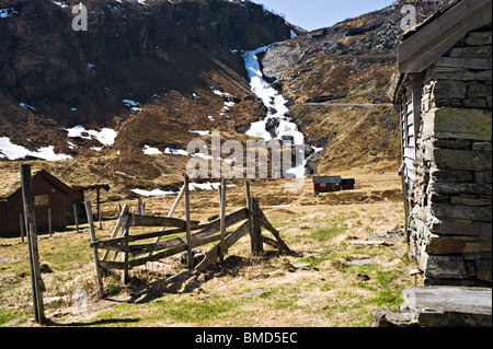 Cabine di vacanza in remoto la holo Valley che scorre veloce con cascata a cascata verso il basso Hillside Sogn Norvegia Foto Stock
