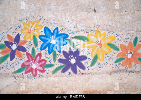 Bambini illustrazioni colorate decora un vecchio muro stucco in corona, Nuovo Messico. Foto Stock