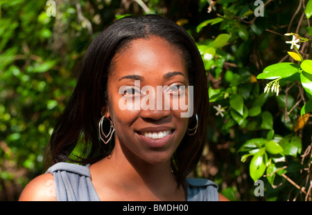 Bella americano africano nero donna di età compresa tra 20s ritratto al di fuori dai fiori nella luce del sole Foto Stock