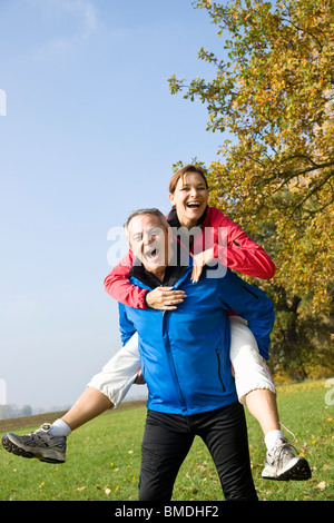 Uomo Donna dando Piggy Back Ride Foto Stock