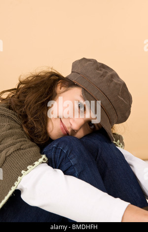 Ragazza adolescente abbracciando le ginocchia Foto Stock