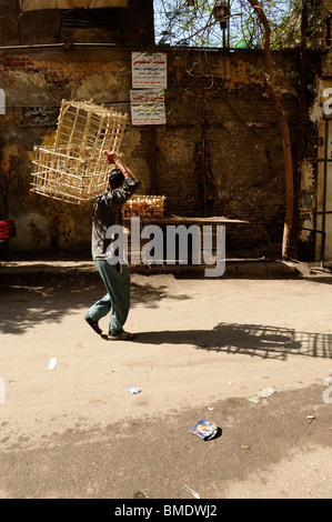 Giovane uomo che porta vegetale cestini di vimini , ,vicoli del quartiere vecchio,Al Gamaliya, Cairo Islamico ,il Cairo, Egitto Foto Stock