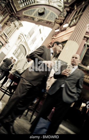 Gli imprenditori della città di Londra a bere una birra al di fuori di un pub nel mercato Leadenhall Londra Foto Stock