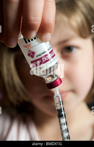 6 anno vecchia ragazza elaborazione di iniezione di insulina Foto Stock