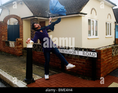 Giovane donna di essere soffiata via dal forte vento in appropriatamente chiamato beaufort road in Portsmouth Inghilterra Foto Stock