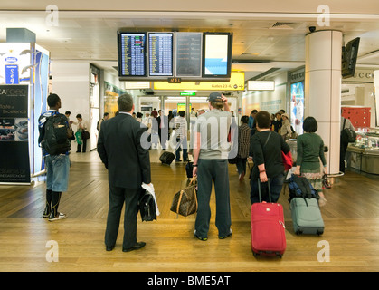 I passeggeri in attesa del loro volo, terminale 3, aeroporto di Heathrow London REGNO UNITO Foto Stock