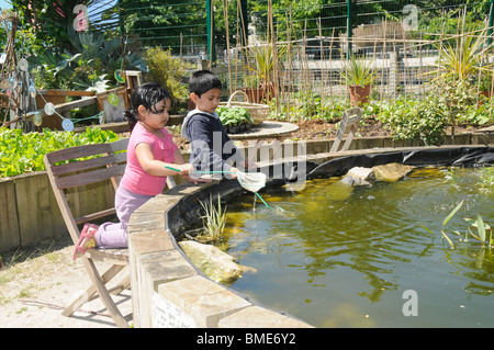 UK BENGALI bambini che giocano al laghetto a SPITALFIELDS CITY FARM A LONDRA Foto Stock