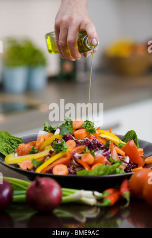 Donna versando olio su verdure, Svezia. Foto Stock