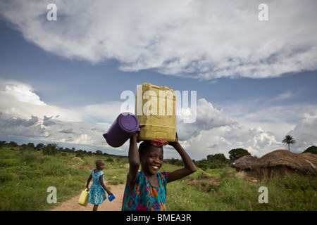 Bambino che trasportano l'acqua in un villaggio - Quartiere Amuria, Uganda. Foto Stock