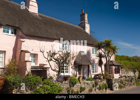 Regno Unito, Inghilterra, Devon, Strete e idilliaco dipinte in colori pastello cottage con il tetto di paglia che si affaccia sul mare Foto Stock