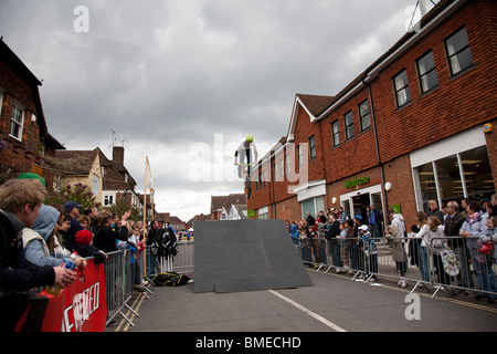 Una BMX rider si prepara a terra su una rampa durante un display acrobatico, Haslemere, Surrey, Inghilterra. Foto Stock