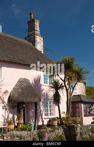 Regno Unito, Inghilterra, Devon, Strete e idilliaco dipinte in colori pastello cottage con il tetto di paglia che si affaccia sul mare Foto Stock