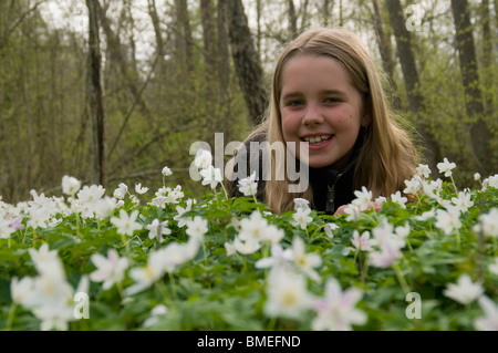 La Scandinavia, Svezia, Smaland, ragazza con anemoni bianchi in primo piano, sorridente, ritratto Foto Stock