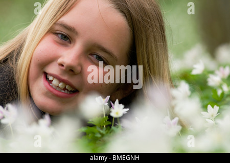 La Scandinavia, Svezia, Smaland, ragazza con anemoni bianchi in primo piano, sorridente, ritratto Foto Stock