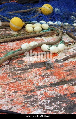 I pescatori professionali di affrontare net su barca grunge invecchiato in legno deck umido Foto Stock