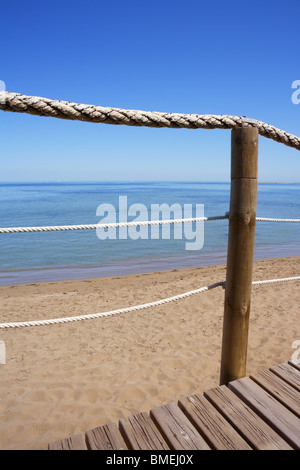 Passerella in legno ringhiera corda sulla spiaggia del mare azzurro orizzonte di estate Foto Stock